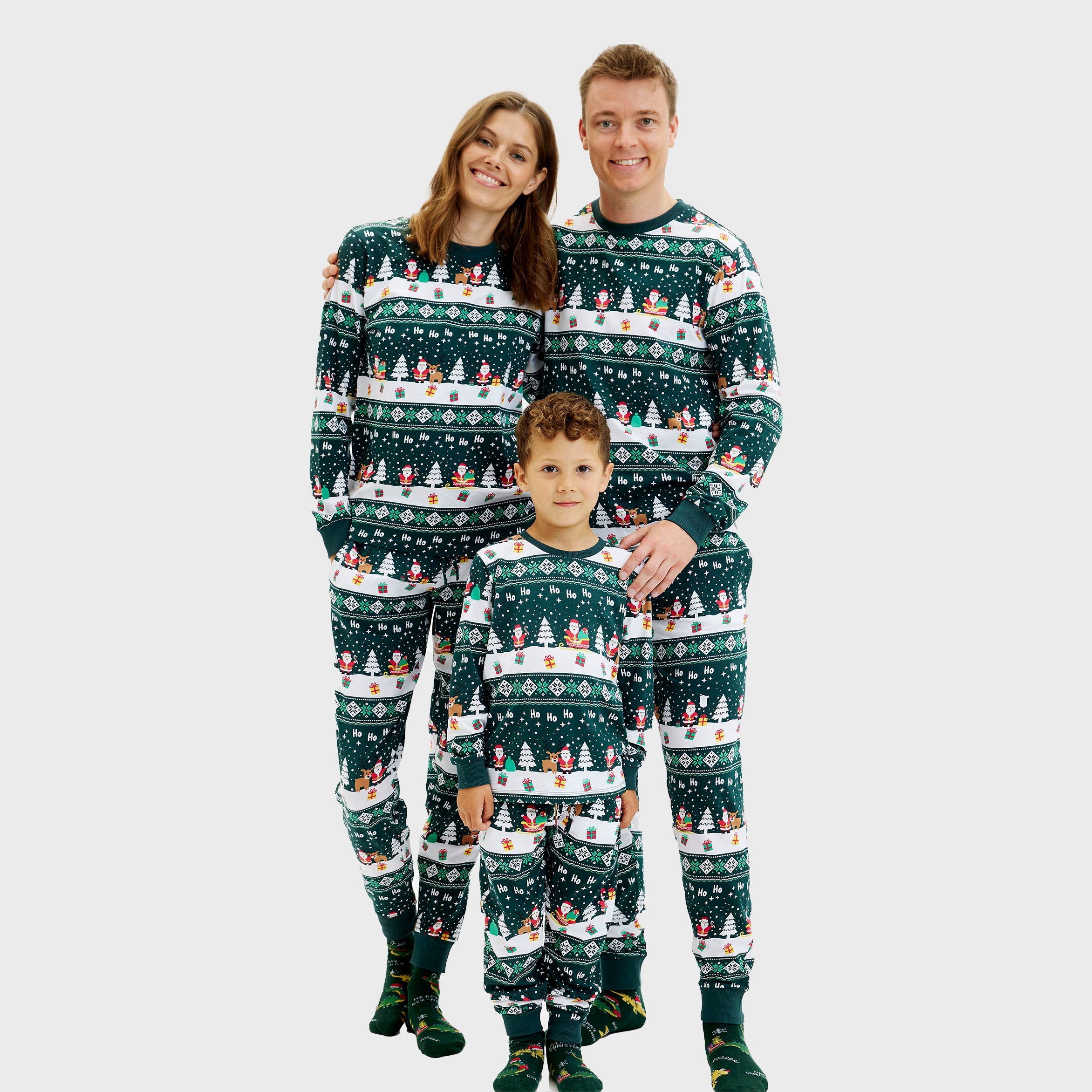 Grüne Weihnachtspyjama Herren, Damen und Kinder mit festlichem Muster aus Rentieren und Schneeflocken.