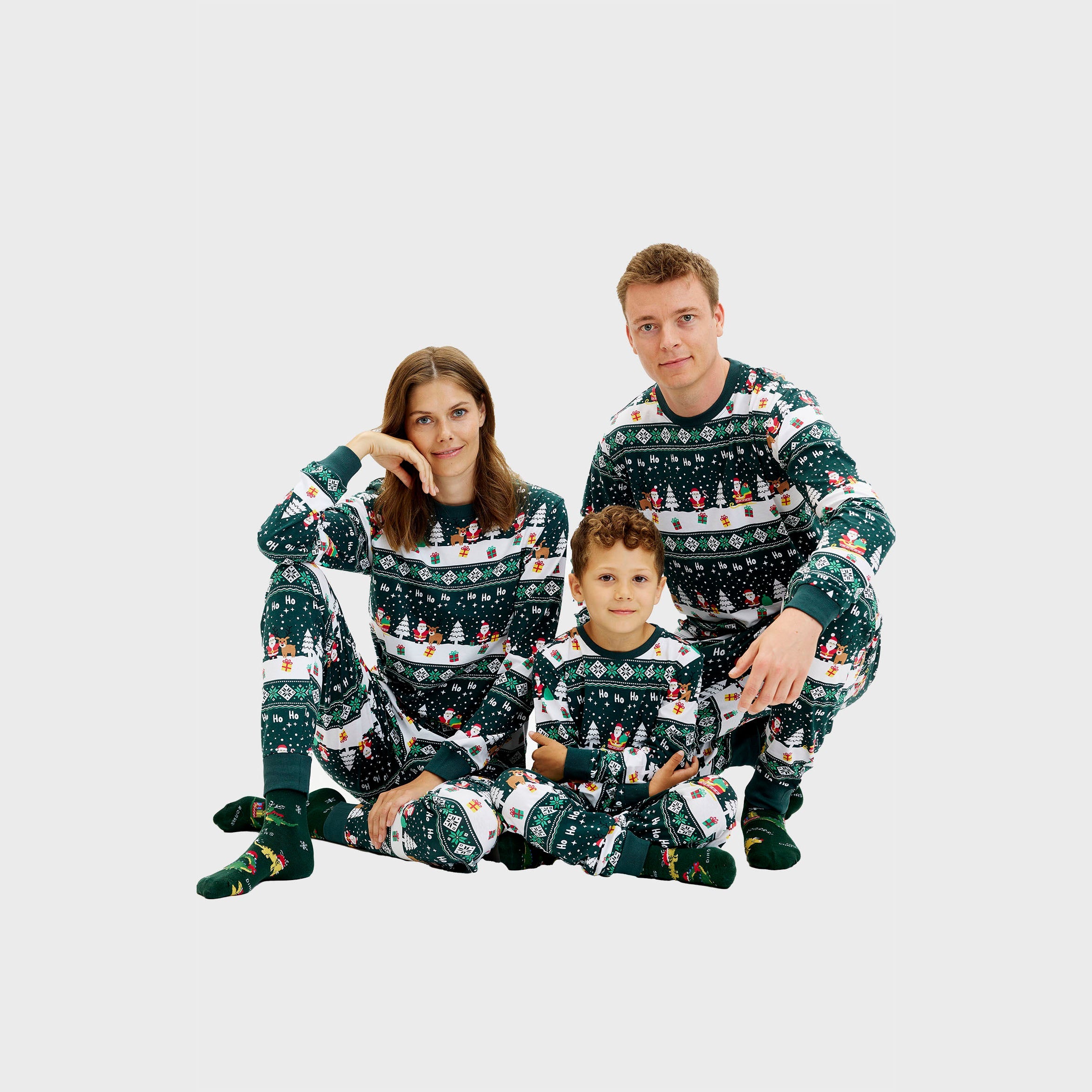 Matching Weihnachtspyjama-Set für Herren, Damen und Kinder mit grünem Rentier- und Schneeflockenmuster.