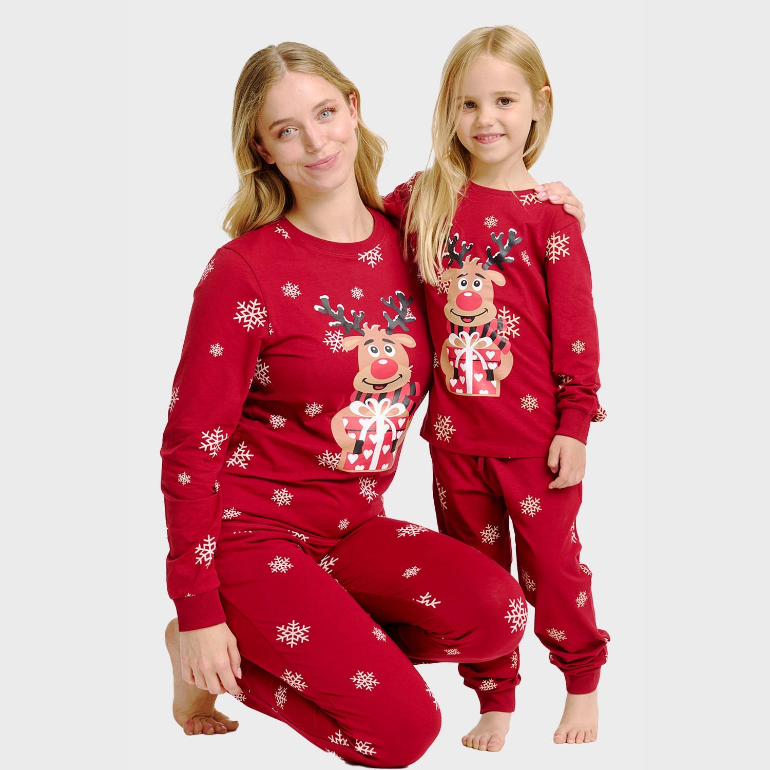 Roter Weihnachtspyjama Kinder mit Rentiermotiv und Schneeflocken, gemütlich und nachhaltig.