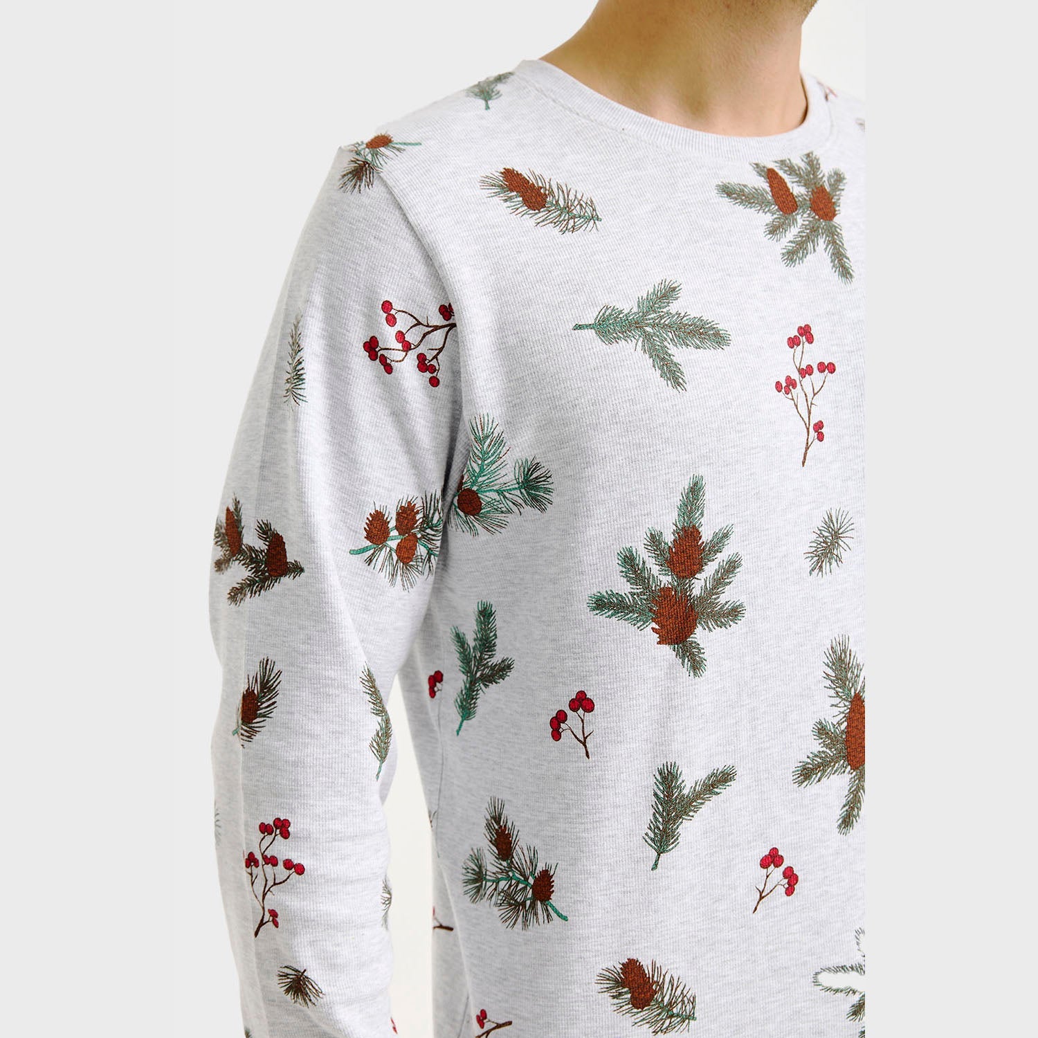 Weihnachtspyjama Damen mit weißem Hintergrund, grünen Tannenzweigen und roten Beerenmuster.