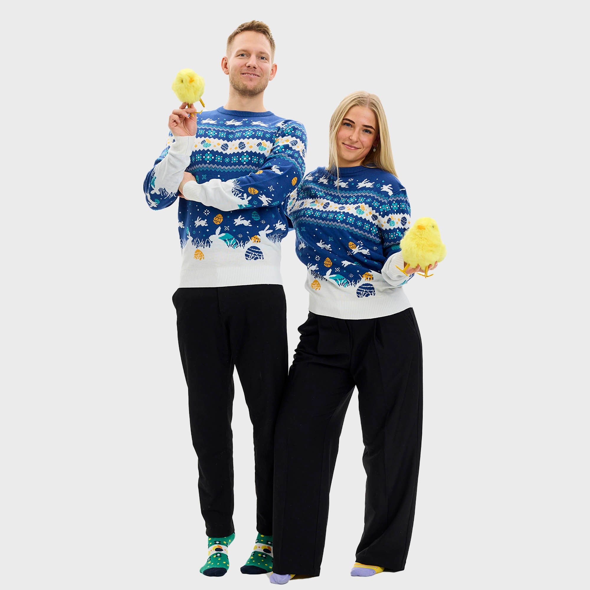 Ein Paar mit blauem Osterpulli und Ostereiern