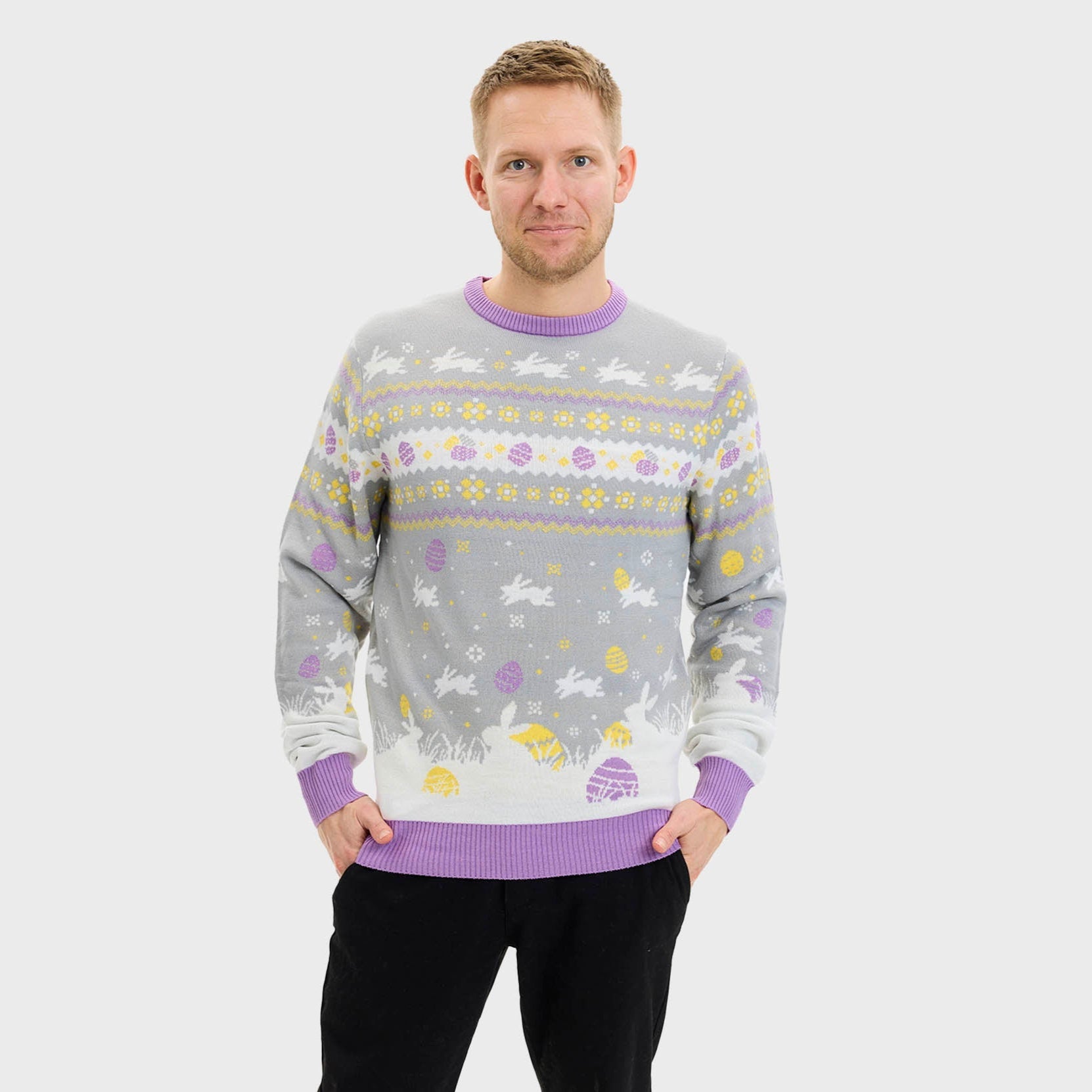 Eine lächelnde Frau, die einen grauen Osterpulli mit Ostereiern trägt.