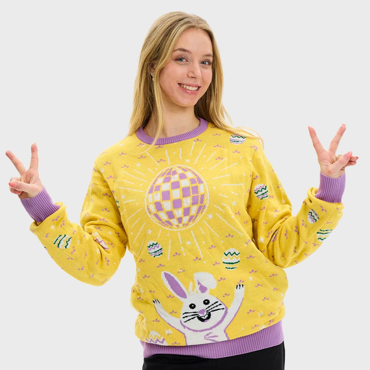 Eine Frau trägt einen gelben Osterpulli.
