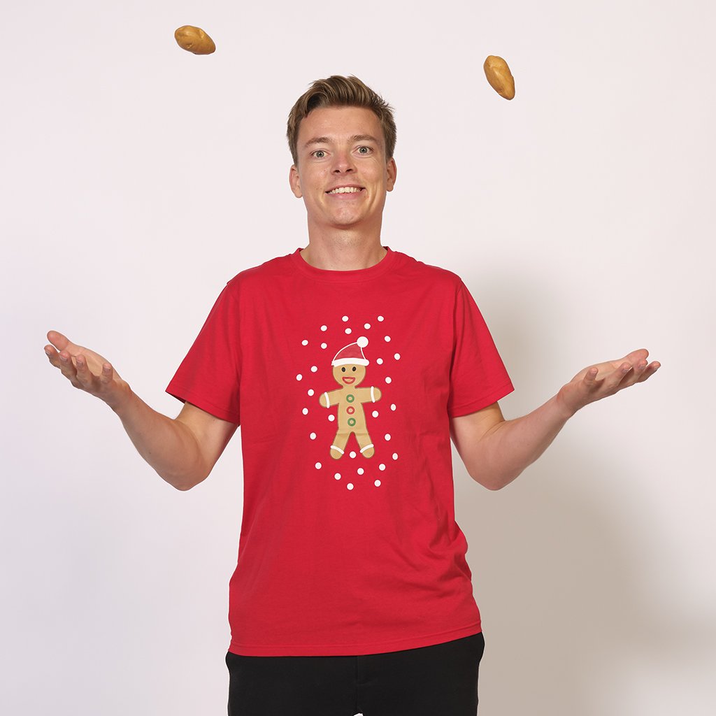 Eine Frau trägt ein rotes T-Shirt mit einem Tortenmann darauf.