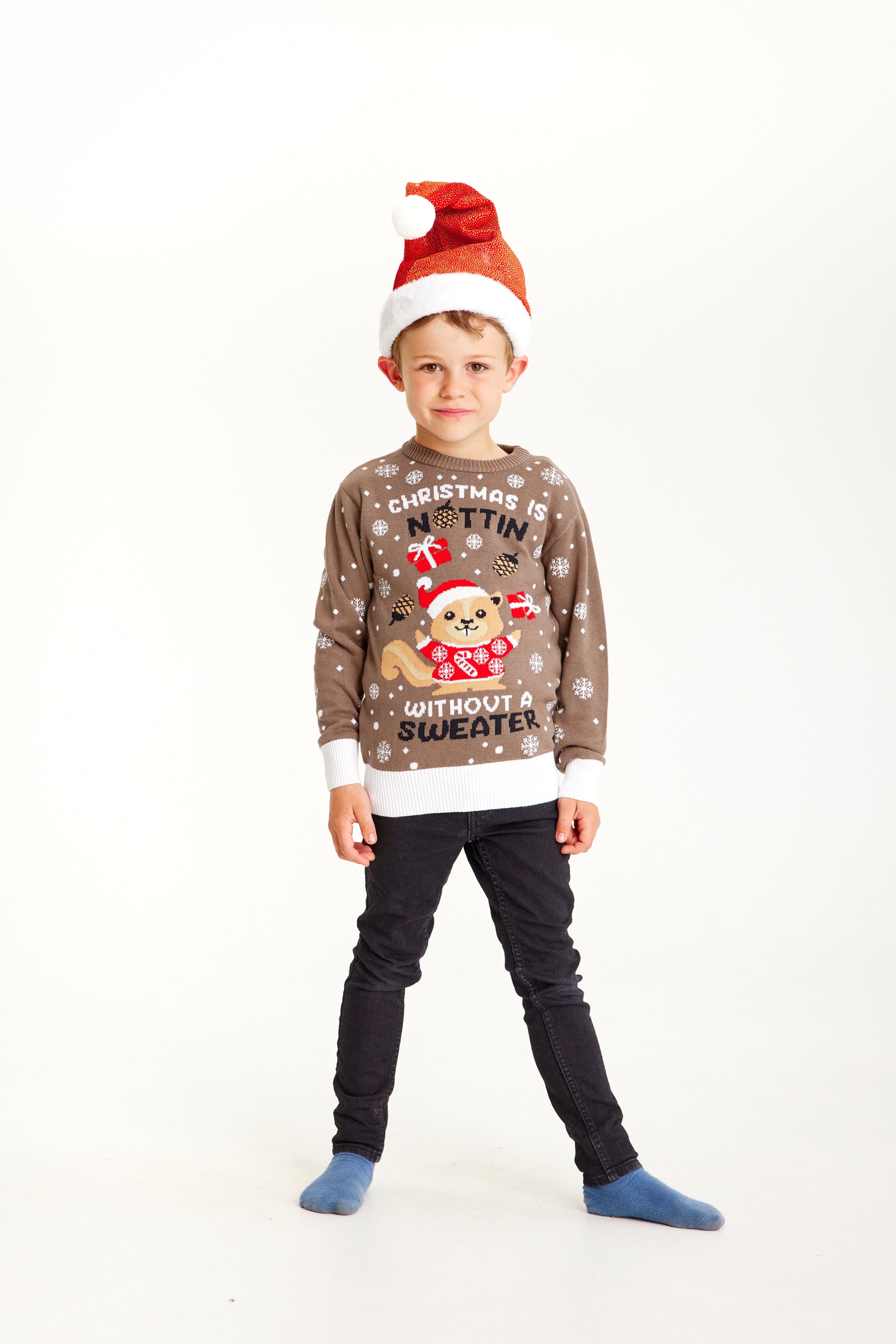 Ein Kind, das einen braunen Weihnachtspulli mit einem Eichhörnchen darauf trägt.