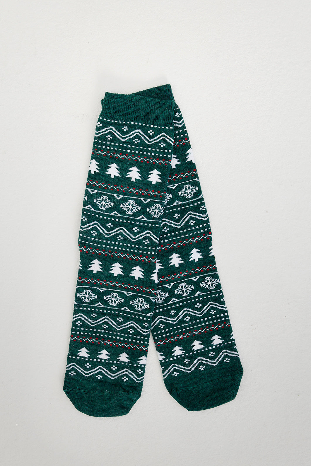 Grüne Weihnachtssocken mit Weihnachtsbäumen darauf.