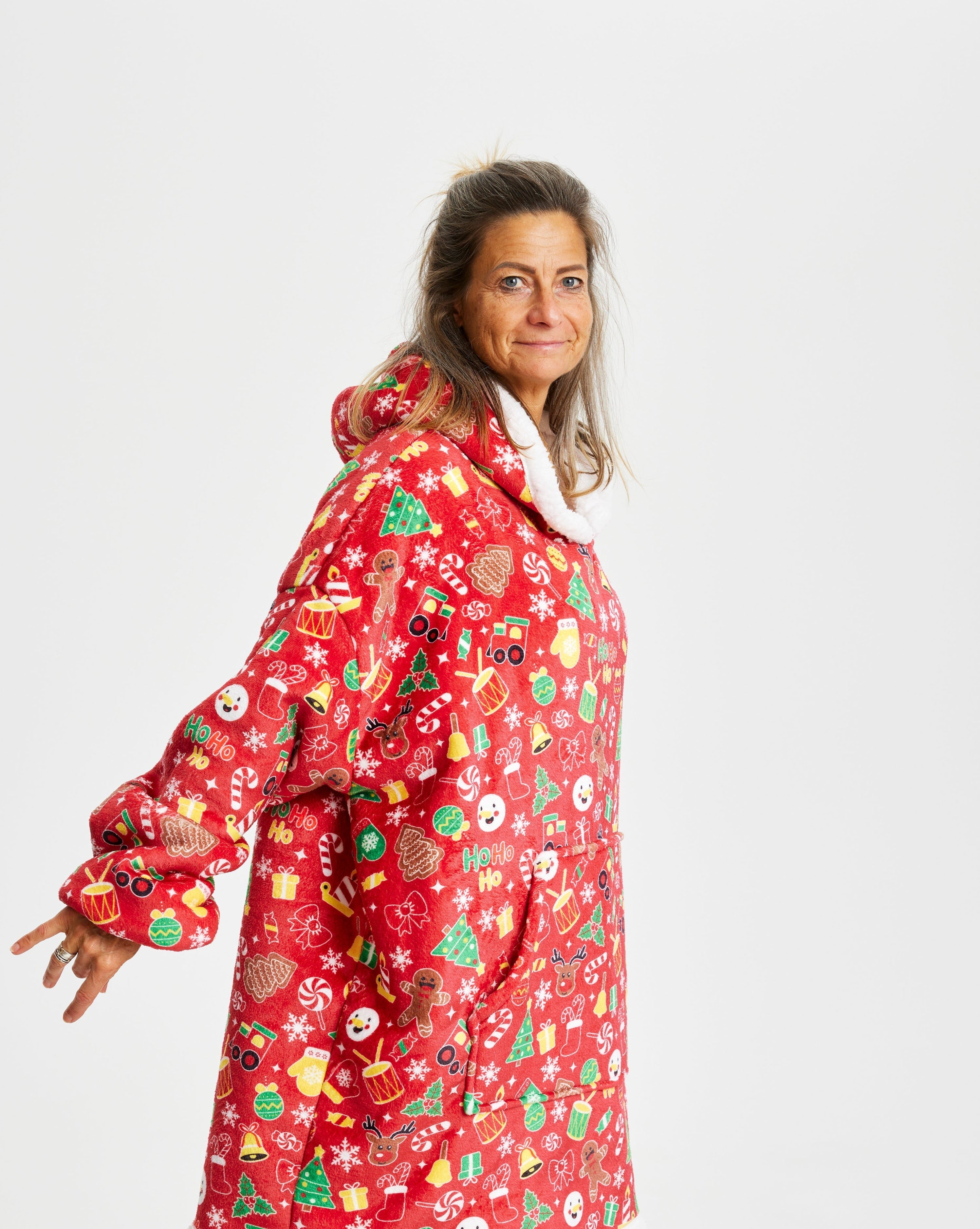 Eine lächelnde Frau mit einem roten Weihnachtskapuzenpullover.