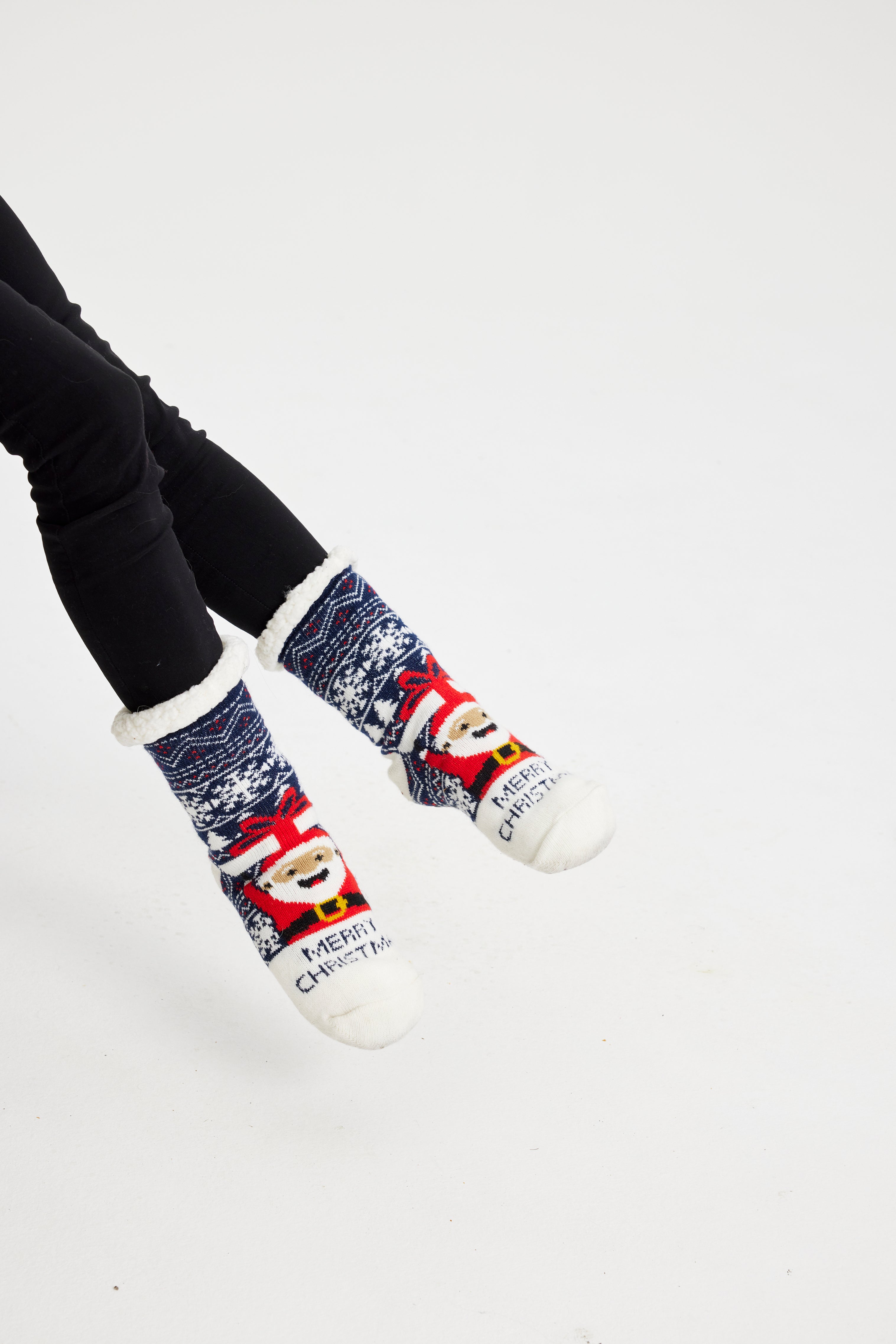 Ein Paar Beine, die ein Paar Weihnachtssocken mit dem Weihnachtsmann darauf tragen.