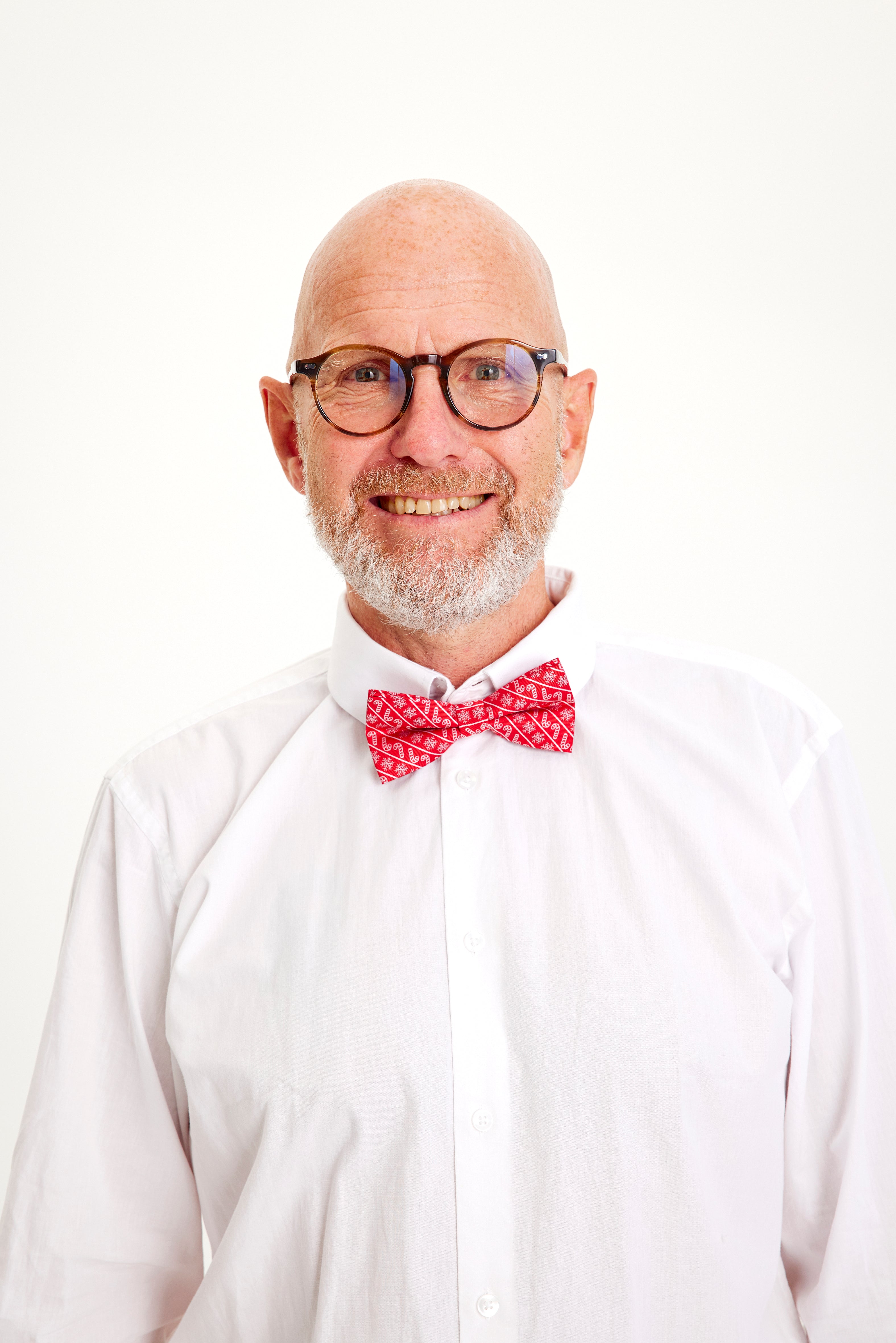 Ein lächelnder Mann mit einer roten Fliege.