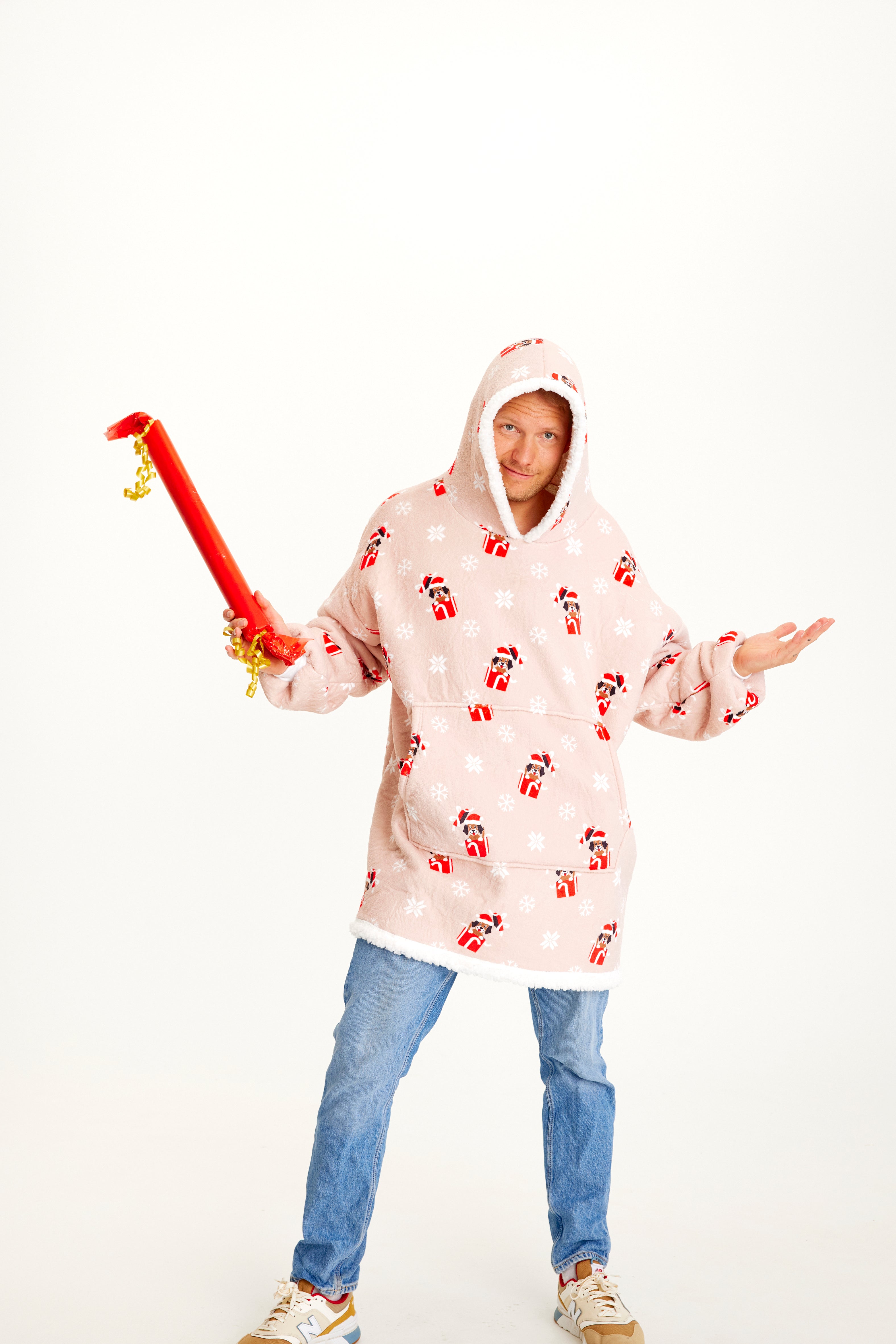 Ein Mann trägt einen rosafarbenen Weihnachtskapuzenpullover mit Hunden darauf.