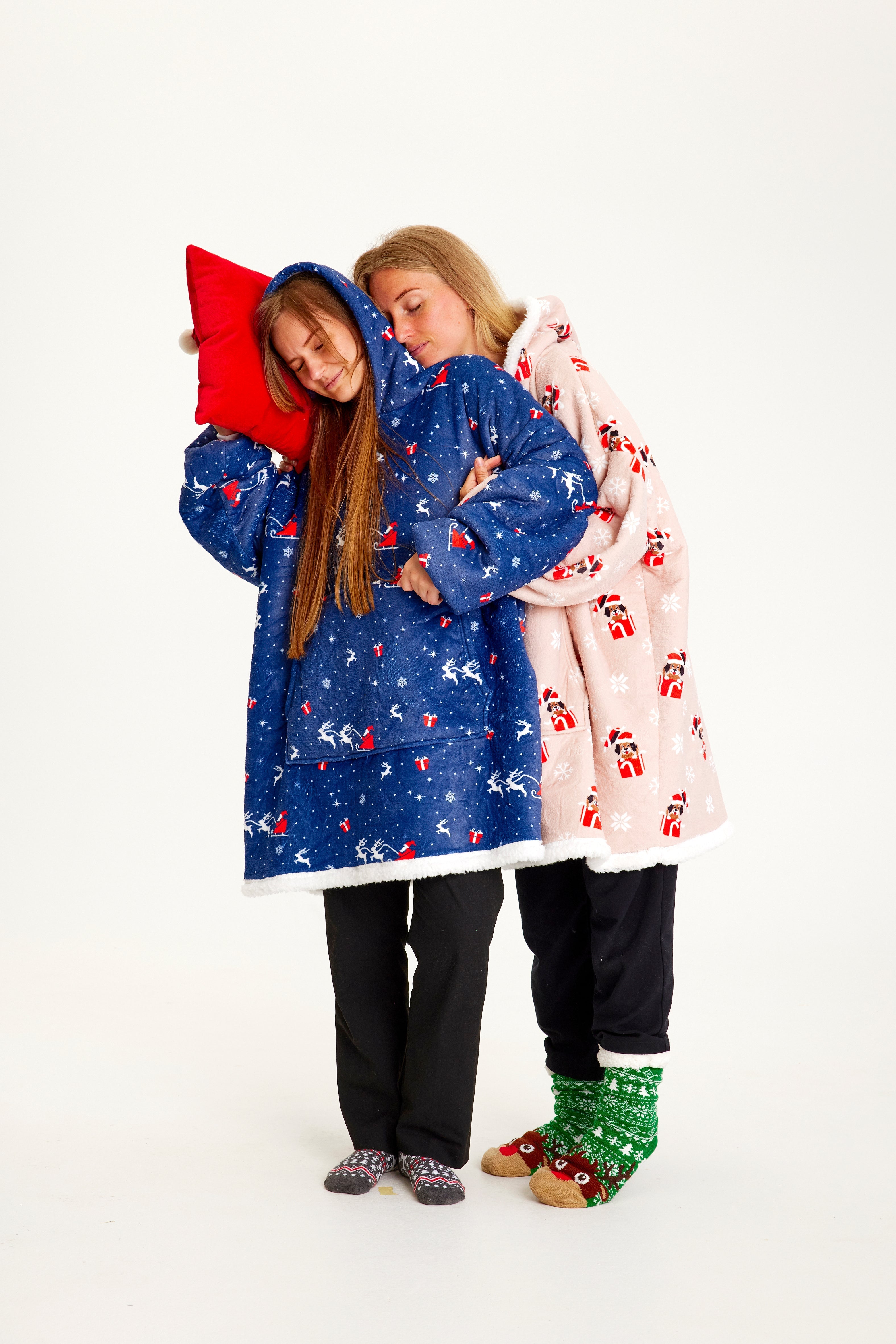 Zwei Frauen, die einen gemusterten Weihnachts-Kapuzenpullover tragen.